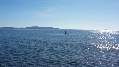 Male-on-a-stand-up-paddle-board-aerial-shot-sunny-day-french-riviera-calm